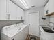 Bright laundry room featuring white cabinets, modern appliances, and a sink with marble countertops at 2680 Clubhouse Dr, Lake Wales, FL 33898