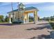 Gated community entrance with a yellow guardhouse and brick pavement at 3020 Caneel St, Winter Haven, FL 33884