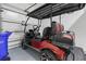 Red golf cart in the garage, ready for Florida fun at 3020 Caneel St, Winter Haven, FL 33884