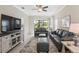 Living room features gray leather couches, a large TV, and a ceiling fan at 3020 Caneel St, Winter Haven, FL 33884