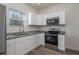 Updated kitchen featuring stainless steel appliances and white cabinets at 412 2Nd Sw St, Winter Haven, FL 33880