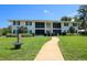 Well-maintained two-story condo building featuring a lush lawn and inviting walkway, with black shutters at 711 Springer Dr # 2, Lake Wales, FL 33853