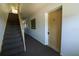 Well-lit hallway featuring a carpeted floor and staircase leading to unit #2 at 711 Springer Dr # 2, Lake Wales, FL 33853