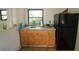 This kitchen area features wooden cabinets, a stainless steel sink, and a black refrigerator at 711 Springer Dr # 2, Lake Wales, FL 33853