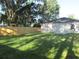 Spacious backyard featuring lush green grass, a wooden fence, and the exterior of the home at 815 S Seminole Ave, Fort Meade, FL 33841
