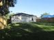 View of the home's exterior, surrounded by a grassy yard and a wooden privacy fence at 815 S Seminole Ave, Fort Meade, FL 33841
