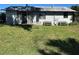 Backyard of property featuring a gray home with window and benches at 1385 N Lake Reedy Blvd, Frostproof, FL 33843