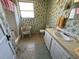 Bathroom featuring a patterned wall, single sink vanity, toilet, and shower with a wicker chair at 1385 N Lake Reedy Blvd, Frostproof, FL 33843