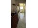 Hallway view leading to a full bathroom featuring textured tile flooring and storage cabinet at 1385 N Lake Reedy Blvd, Frostproof, FL 33843