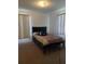 Bright bedroom with large windows, plush carpet, ceiling fan, and comfortable striped bedding at 1402 Thousand Roses Dr. W. # 1402, Lake Wales, FL 33853