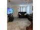Cozy living room featuring tile floors, black leather couches, tv, and a ceiling fan at 1402 Thousand Roses Dr. W. # 1402, Lake Wales, FL 33853