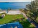 Aerial view of a lakefront property with a private dock, beach, and lush green lawn at 1800 N Scenic Hwy, Babson Park, FL 33827