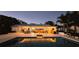 Backyard view of the outdoor seating area, pool, and beautiful home at twilight at 1800 N Scenic Hwy, Babson Park, FL 33827