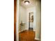 Hallway with wood floors that leads to the bathroom with modern vanity and mirror at 1800 N Scenic Hwy, Babson Park, FL 33827