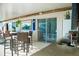 A covered outdoor kitchen with a bar, sink, and stainless steel refrigerator, seamlessly connecting indoor and outdoor living at 1800 N Scenic Hwy, Babson Park, FL 33827