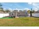 A view of the home's backyard featuring lawn space, patio, outdoor dining set, and privacy fence at 1831 Richmond Rd, Lakeland, FL 33803