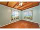 Cozy bedroom with wood floors, unique ceiling, and windows with decorative curtains at 1831 Richmond Rd, Lakeland, FL 33803