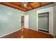 A bedroom with wood floors features an open closet and a view into an adjacent room at 1831 Richmond Rd, Lakeland, FL 33803