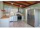 Modern kitchen features stainless steel appliances, butcher block countertops, and gray cabinets at 1831 Richmond Rd, Lakeland, FL 33803