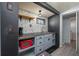 A compact kitchenette features gray cabinets, a red microwave, and a patterned wallpaper at 1831 Richmond Rd, Lakeland, FL 33803