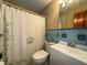 Cozy bathroom featuring a tub with shower curtain, toilet, and vanity sink at 1893 N Lake Reedy Blvd, Frostproof, FL 33843