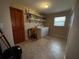 Well-lit laundry room with washer, dryer, shelving, and tile flooring at 1893 N Lake Reedy Blvd, Frostproof, FL 33843