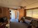 A living room features wood paneling, a sofa, and fan, providing a cozy area for relaxation at 1893 N Lake Reedy Blvd, Frostproof, FL 33843