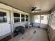 Covered porch with concrete flooring, ceiling fan, white trim windows and furniture at 1893 N Lake Reedy Blvd, Frostproof, FL 33843