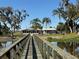 Picturesque view of the property from a wooden bridge, highlighting the home and waterfront setting at 1893 N Lake Reedy Blvd, Frostproof, FL 33843