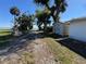 Scenic view of the property, featuring a lake, a shed, and gravel driveway on a sunny day at 1893 N Lake Reedy Blvd, Frostproof, FL 33843