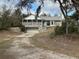 View of a charming stone house with a screened porch and built in garage at 2134 R E Byrd Rd, Frostproof, FL 33843