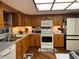 Efficient kitchen design featuring wood cabinets, matching appliances, and under cabinet lighting at 2134 R E Byrd Rd, Frostproof, FL 33843