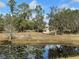 Relaxing view of a lily pad filled pond with lush trees reflecting in the water and the house in the background at 2134 R E Byrd Rd, Frostproof, FL 33843