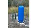 Well system with blue tank, pump, and connections surrounded by vegetation at 2134 R E Byrd Rd, Frostproof, FL 33843