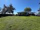 Waterfront home with a lush lawn and a covered carport area at 2263 Lake Reedy N Blvd, Frostproof, FL 33843