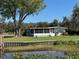 Charming single-story home featuring a screened porch and manicured lawn, overlooking a tranquil waterfront at 2263 Lake Reedy N Blvd, Frostproof, FL 33843