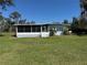 Single Gathering home featuring a screened in porch and lush green lawn at 2263 Lake Reedy N Blvd, Frostproof, FL 33843