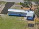 Aerial view of a home with metal roof, fenced yard, built-in fire pit, and driveway at 2391 Buck Board Trl, Lake Wales, FL 33898