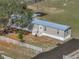 Aerial view of a home with a metal roof, white fence, and fire pit in the backyard at 2391 Buck Board Trl, Lake Wales, FL 33898