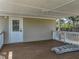 A covered porch with a wood deck and white railing, perfect for outdoor relaxation and entertaining at 2391 Buck Board Trl, Lake Wales, FL 33898