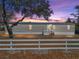 Charming single-story home featuring a metal roof and white picket fence at sunset at 2391 Buck Board Trl, Lake Wales, FL 33898