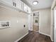 A clean laundry room featuring wood-look floors, white cabinets, and visible washing machine connections at 2391 Buck Board Trl, Lake Wales, FL 33898