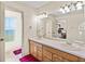 Well-lit bathroom featuring double sinks, a large mirror, and a doorway leading to another room at 2656 S Scenic Hwy, Lake Wales, FL 33898