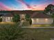 Beautiful shot of home at twilight, featuring mature landscaping and a well manicured lawn at 2656 S Scenic Hwy, Lake Wales, FL 33898