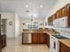 Well-lit kitchen features wood cabinetry, stone countertops, tile flooring, stainless steel dishwasher, and a breakfast bar with lake view at 2656 S Scenic Hwy, Lake Wales, FL 33898