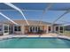 A covered patio outside boasts a dining and cooking area, adjacent to a sparkling pool at 2656 S Scenic Hwy, Lake Wales, FL 33898