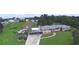 Aerial view showcasing a well-kept home with a spacious green lawn and a covered carport at 301 S Clinch Lake Blvd, Frostproof, FL 33843