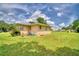 Spacious backyard with lush green grass and a cozy bench seating area under a window at 301 S Clinch Lake Blvd, Frostproof, FL 33843