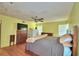 Bright bedroom featuring a ceiling fan, wooden floors, and a comfortable queen-sized bed at 301 S Clinch Lake Blvd, Frostproof, FL 33843