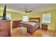 Sunlit bedroom showcasing hardwood floors, classic furnishings, and comfortable sleeping arrangements at 301 S Clinch Lake Blvd, Frostproof, FL 33843